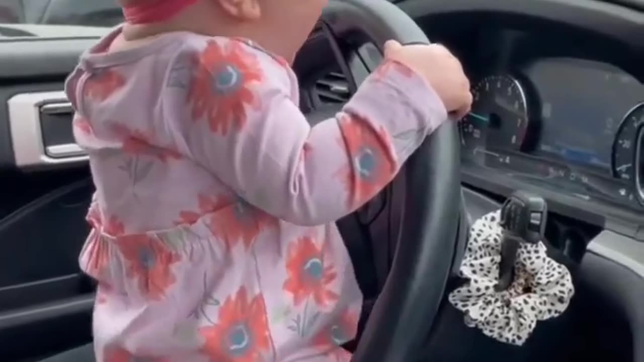 Cute baby trying to drive the car