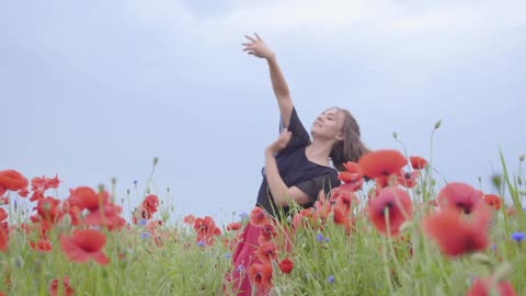 Girl dancing happily in a field of flowers