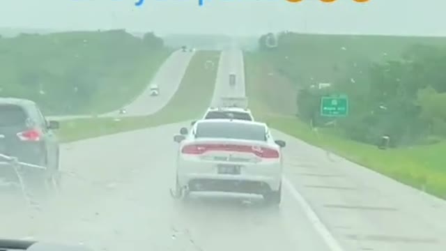 Car Pulls Over To Roadside As Police Vehicle Switches On Their Lights