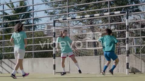 Active Teenage Girls Playing Football Outdoors And One Girl Scores