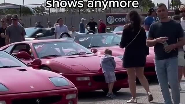 At the auto show, children who are very interested in the cars on display.