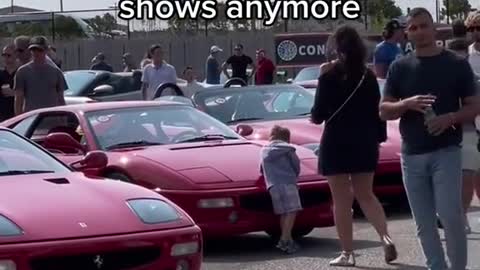 At the auto show, children who are very interested in the cars on display.