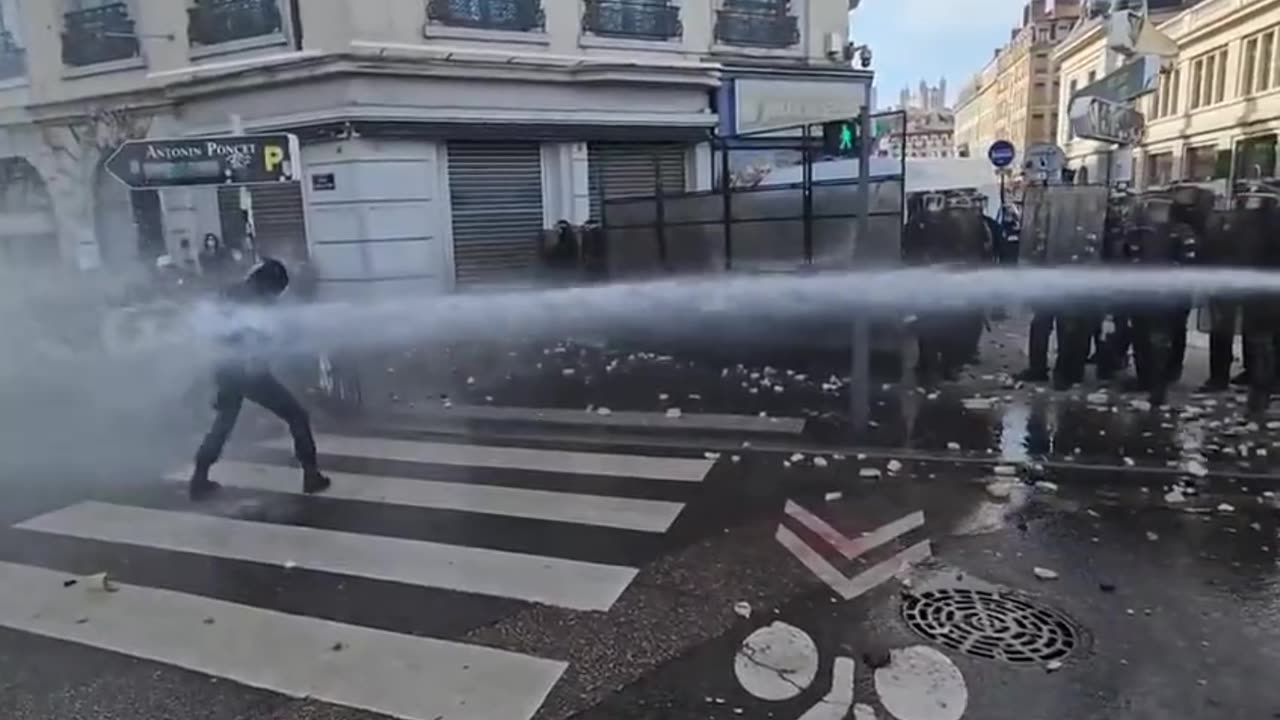 One man takes on the water cannon in Lyon today.