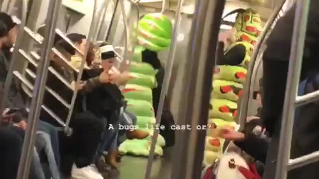 Two people dressed as green caterpillars on subway