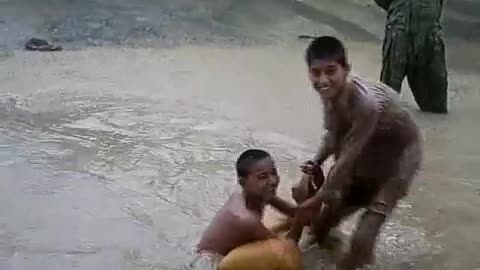 Boys enjoying street water in raining