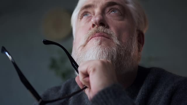 Elderly Man Writing on a Piece of Paper