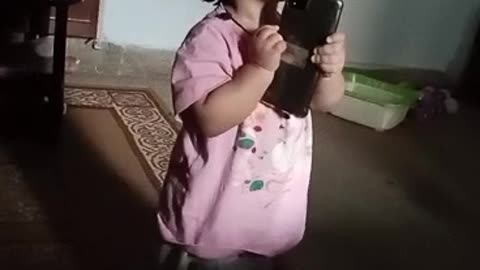 Two year girl talking with grandfather on phone