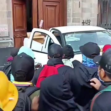 Manifestantes derriban la puerta del palacio presidencial de México.