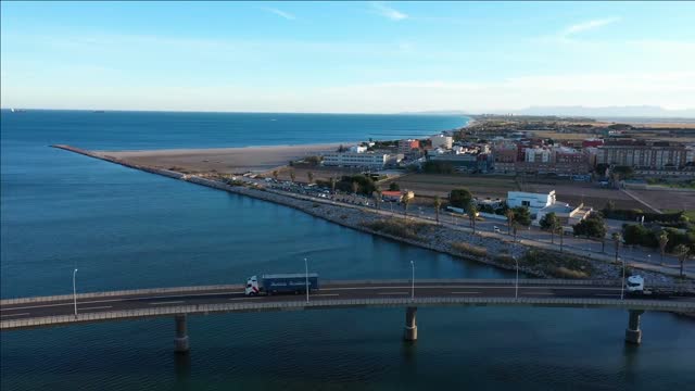 trucks crossing a bridge commercial area valencia pinedo beach aerial shot spain