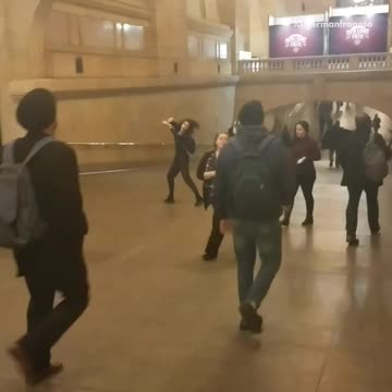 Woman in black outfit dancing in train station