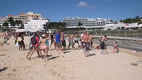 People "flying" behind airplane turbine at the famous airport of Saint Martin CARIBBEAN