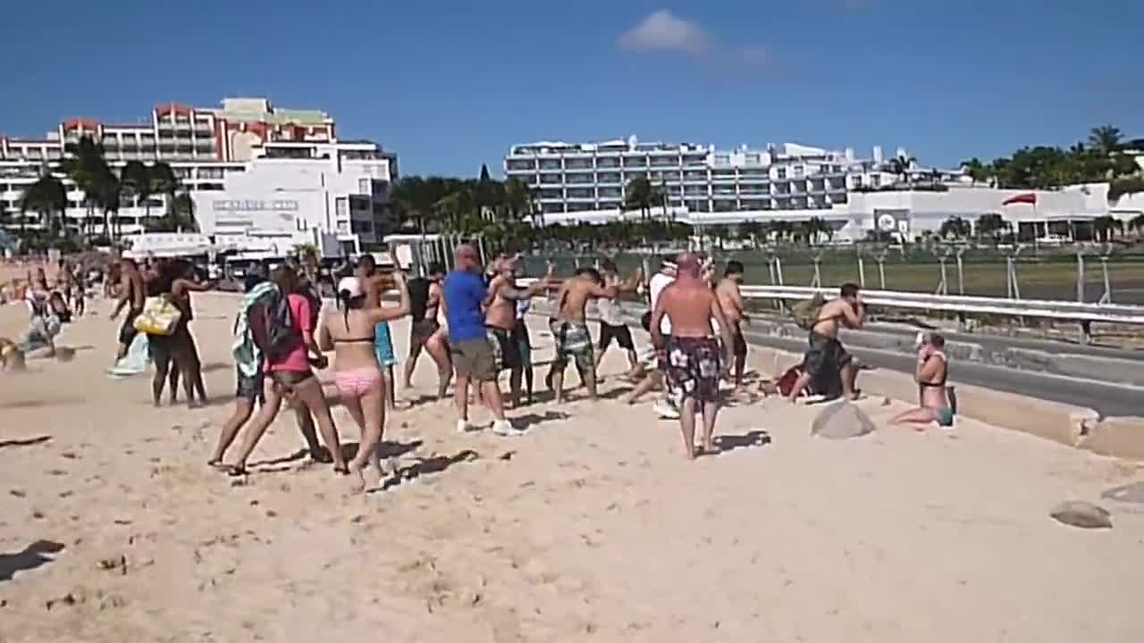 People "flying" behind airplane turbine at the famous airport of Saint Martin CARIBBEAN