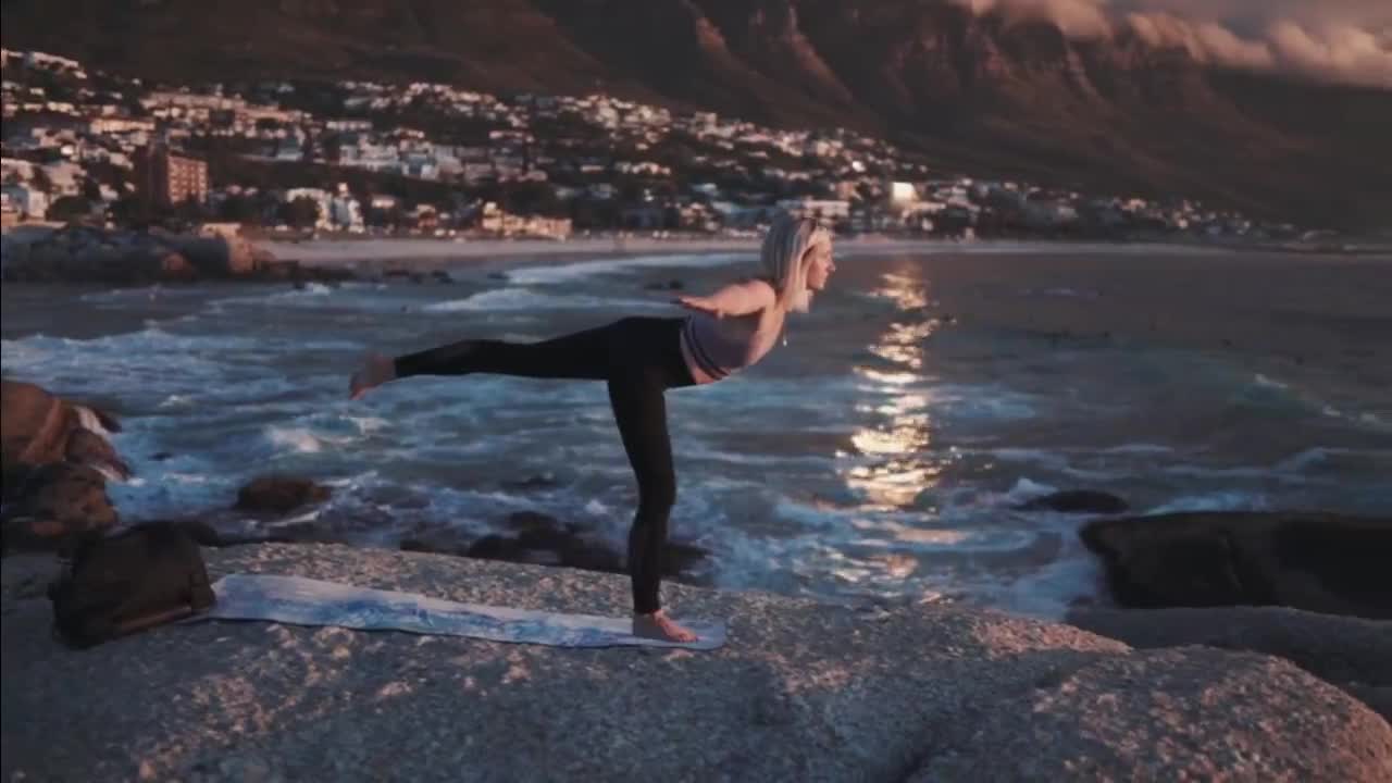 The beauty of yoga on the sea rocks with sunset