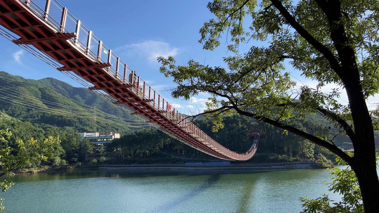 people crossing the rocking bridge over the lake