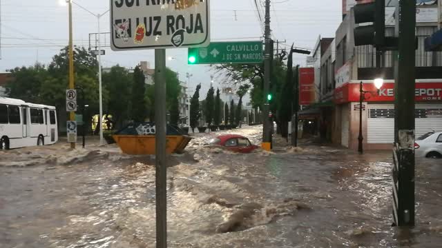 Dumpster Floats Down Flooded Street