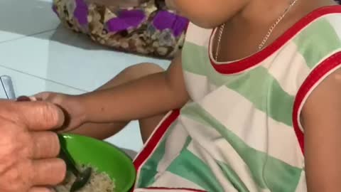 the baby learns to eat rice