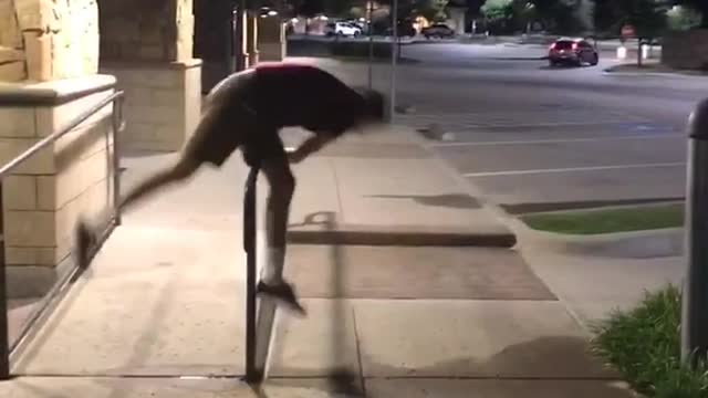 Guy in red shirt jump over rail lands on crotch