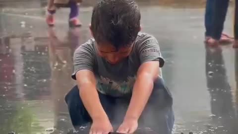 Small fire set inside a scrap tin amid bitter cold and rainfall in Gaza.