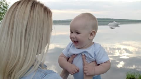 A Mother Playfully Lifting Her Baby Above Head