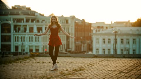 Girl dancing ballet on top of a building
