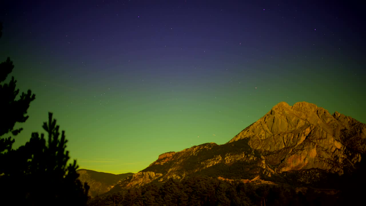 Mountain during a sunset and stars in the sky