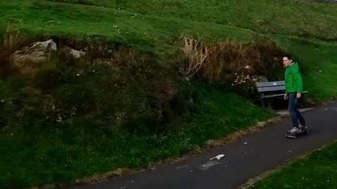 Green sweater skating down hill falls off board and screams