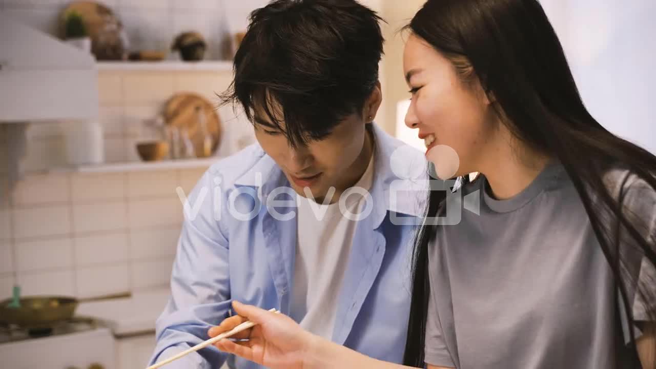 Close Up View Of Japanese Friends Sitting Around The Kitchen Counter Eating Japanese Food 2