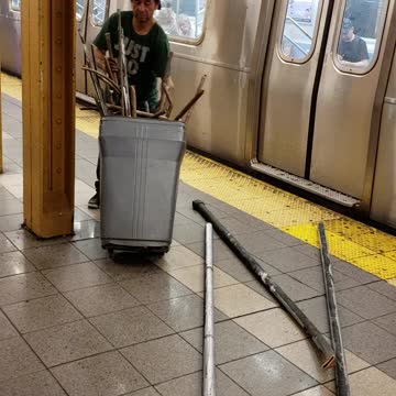 People walking off of subway train with trashcans full of metal and pipes