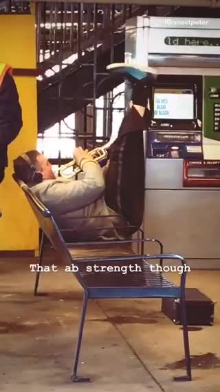 Man doing ab crunches in chair while playing the trumpet