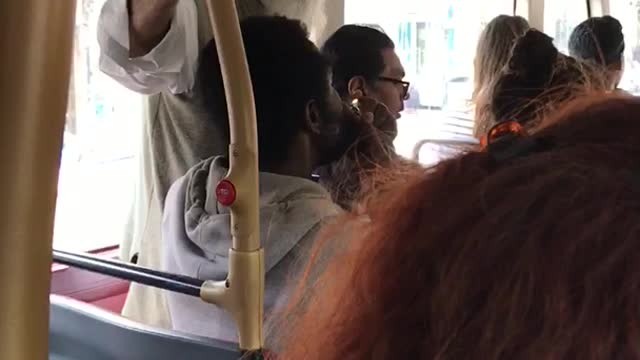 Guy lighting and smoking from a piece on the bus