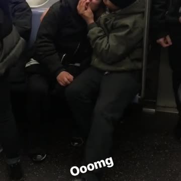 Guy black beanie green jacket squeezing girls lips