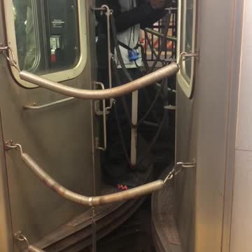 Man costume white mask in between subway cars