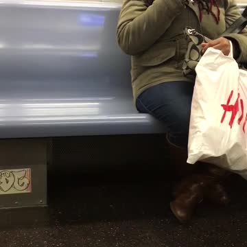 Woman plucks hair from chin on subway