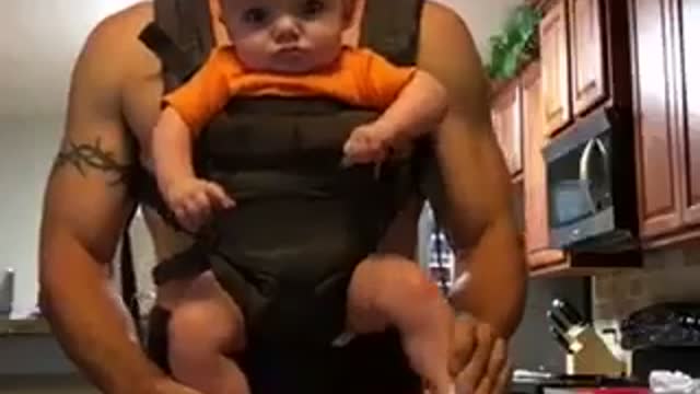 Dad Straps In Son And They Stare Into The Camera, Then The Baby Boy Starts Dancing