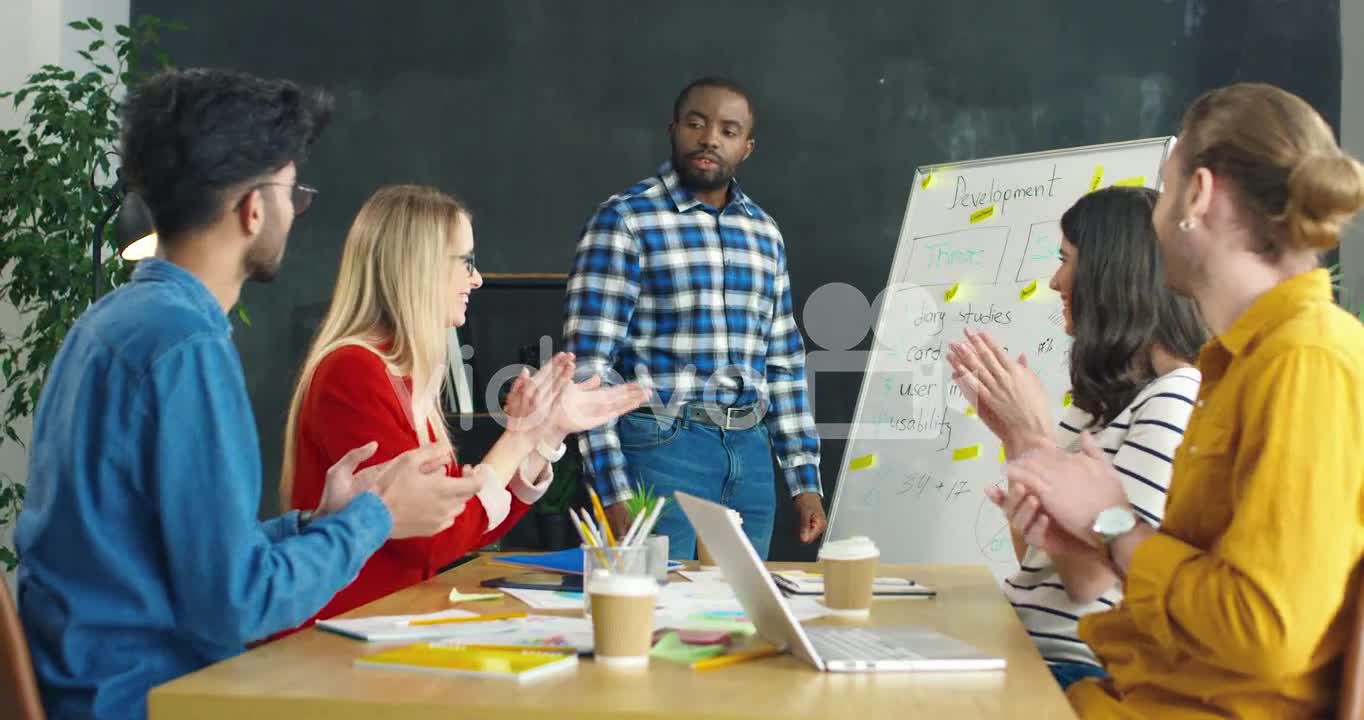 Man Explaining Business Strategy With A Blackboard In The Office, Then His Colleagues Applaud