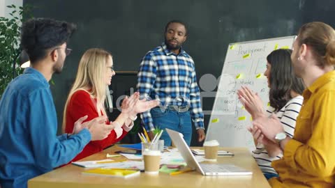 Man Explaining Business Strategy With A Blackboard In The Office, Then His Colleagues Applaud