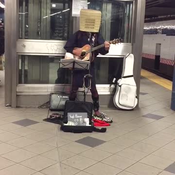 Mezzanine 58 street guy with basket over head playing guitar