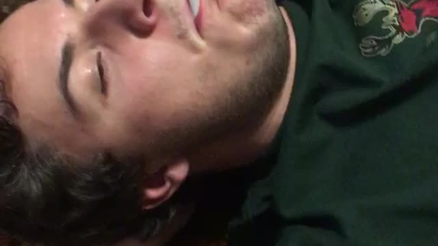 Music guy in green shirt smokes cigarette on the floor