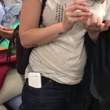 Woman in white shirt clipping nails in subway train