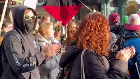 The "red-and-black" flag in front of Greta is the symbol of the anarcho-syndicalist