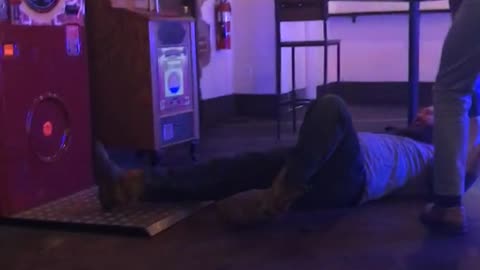 Man in grey with beard kicks game and falls