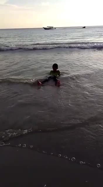 Kid fun to play with the sea waves