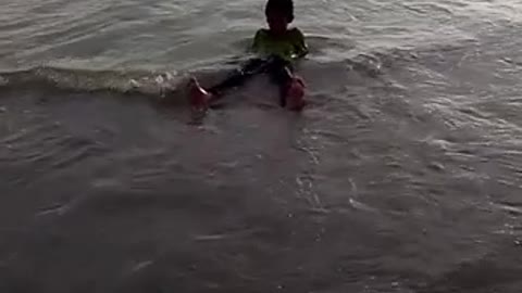 Kid fun to play with the sea waves