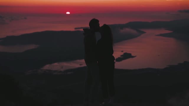 Couple kissing at the top of mountain