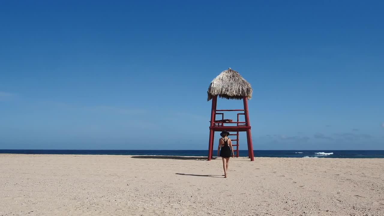 Woman walking barefoot on the beach