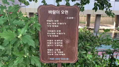 greenery and a signboard with beautiful poem