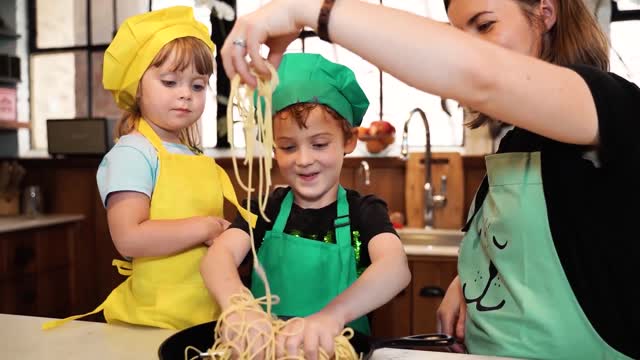 A mother and her two children enjoying pasta