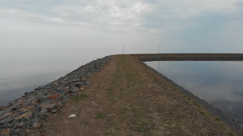 Quadrocopter flies over the embankment on the lake