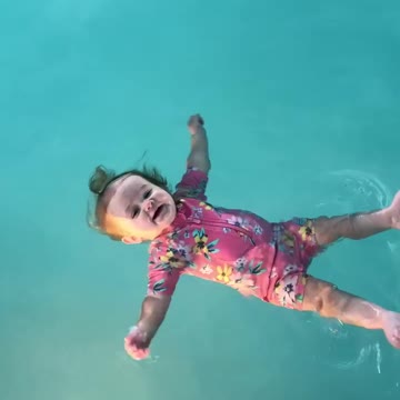 Floating 11-moth-old extremely comfortable in the pool