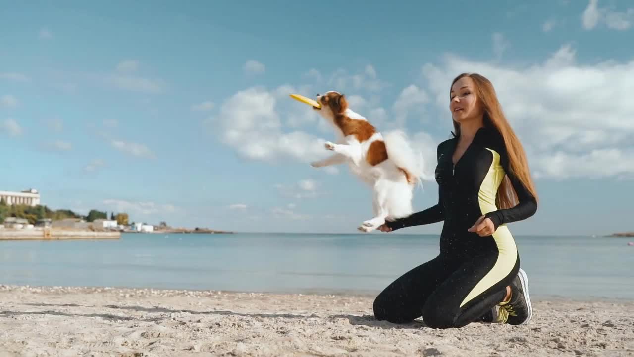 Young adult athlete girl spending day on beach with little dog